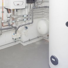 Die Installation zeigt eine Vielzahl von Rohren, Ventilen und einem großen weißen Behälter, der für die Wasserversorgung genutzt wird.