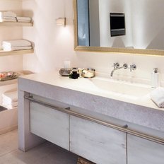 Ein modernes Badezimmer mit einem eleganten Waschbecken, dekorativen Kerzen und stilvollen Pflegeprodukten auf der Ablage.