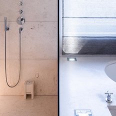 Ein elegantes Badezimmer mit einer modernen Dusche und einer freistehenden Badewanne, umgeben von hellen, minimalistischen Wänden.