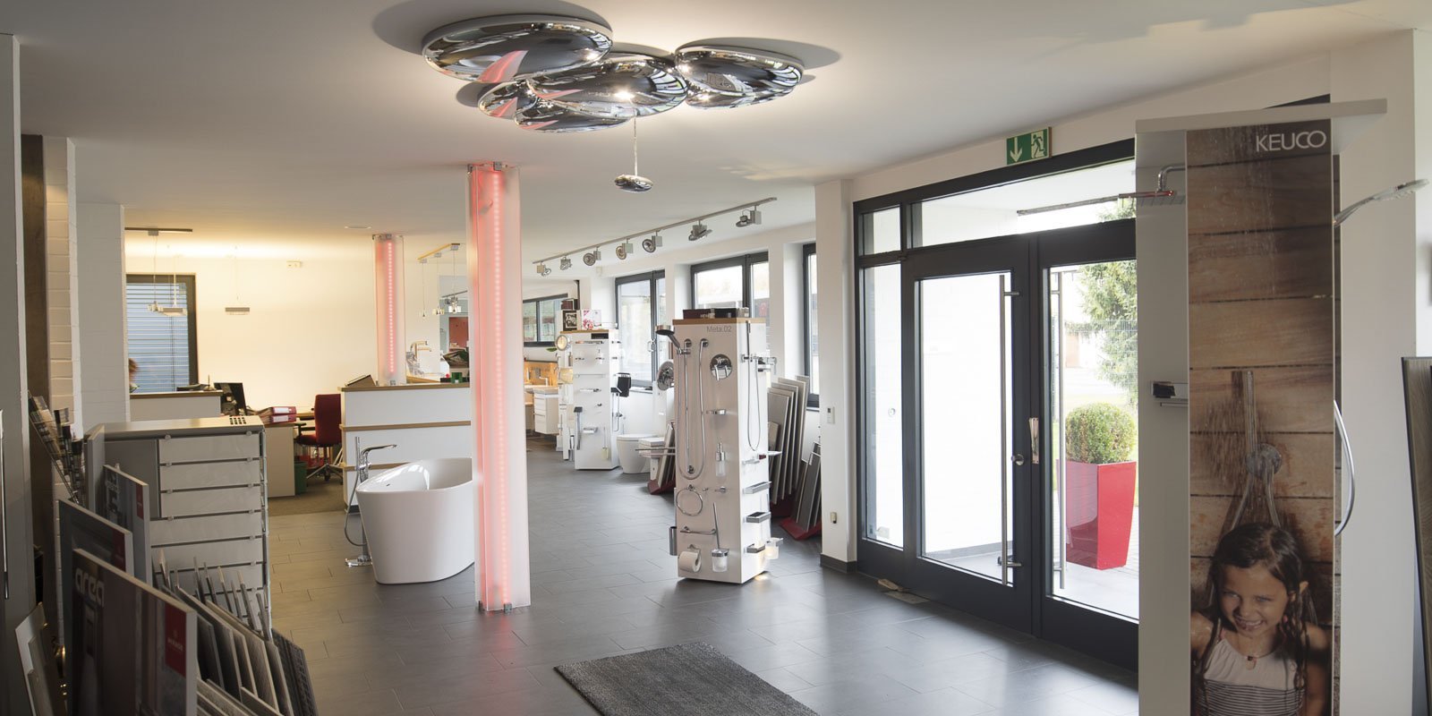 Ein gut gestalteter Ausstellungsraum mit großen Fenstern, der eine Vielzahl von Badezimmerprodukten und -designs präsentiert.